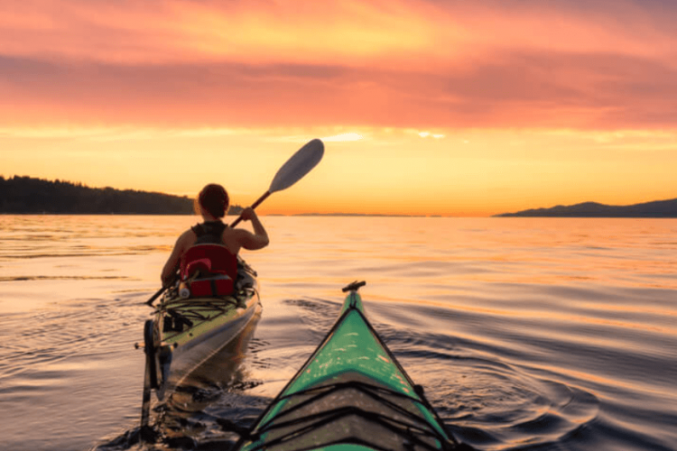 view of two kayaks in the water at sunset