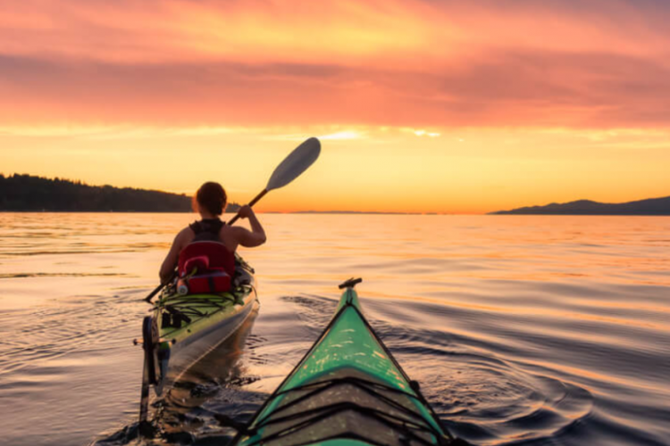 view of two kayaks in the water at sunset