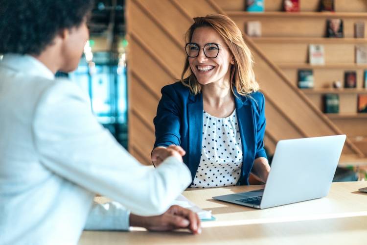 woman shaking hands with client in a meeting