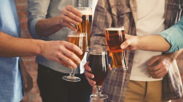 friends holding beer glasses full of beer | Sunset Vacations