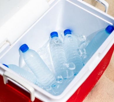 cooler full of bottled water on the beach | Sunset Vacations