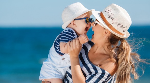 mother and baby enjoying the beach | Sunset Vacations