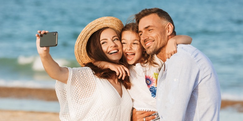 family talking a selfie on the beach | Sunset Vacations